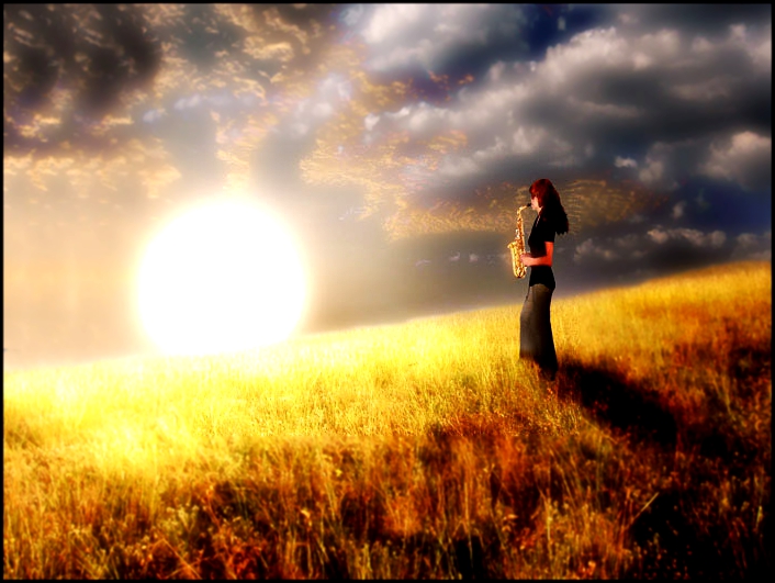 Фото Девушка стоит посреди поля на закате и